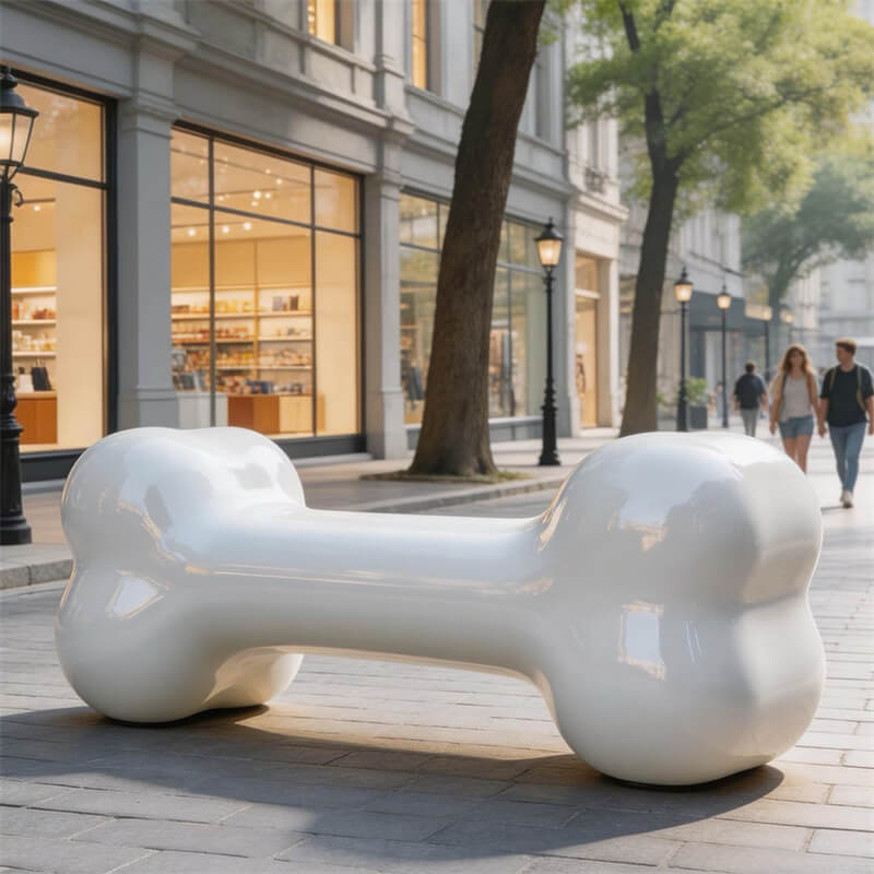 Front-angle view of large white bone-shaped FRP bench on urban street, safe and rounded kids' fiberglass leisure chair