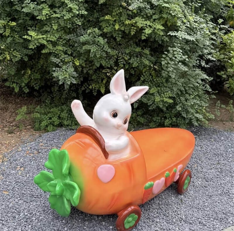 Single‑seat fiberglass carrot bench with a rabbit at the wheel, outdoor leisure seat shot