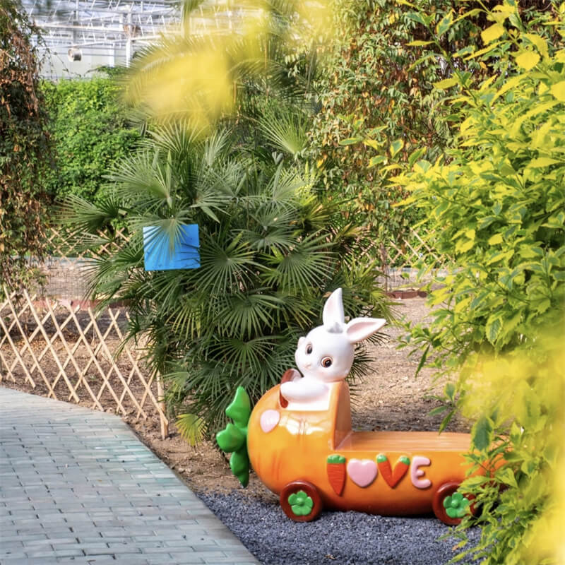 Fiberglass carrot bench along an outdoor path with a carrot‑car design, garden landscape seat