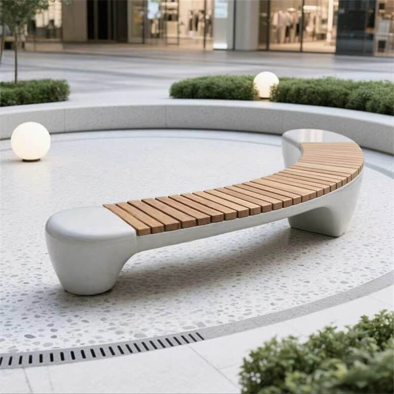 Simple curved fiberglass bench with a solid wood seat in a circular area of an outdoor commercial plaza
