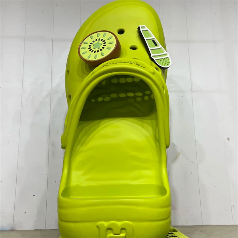 Full front view giant green crocs sculpture with kiwi charms store entrance prop