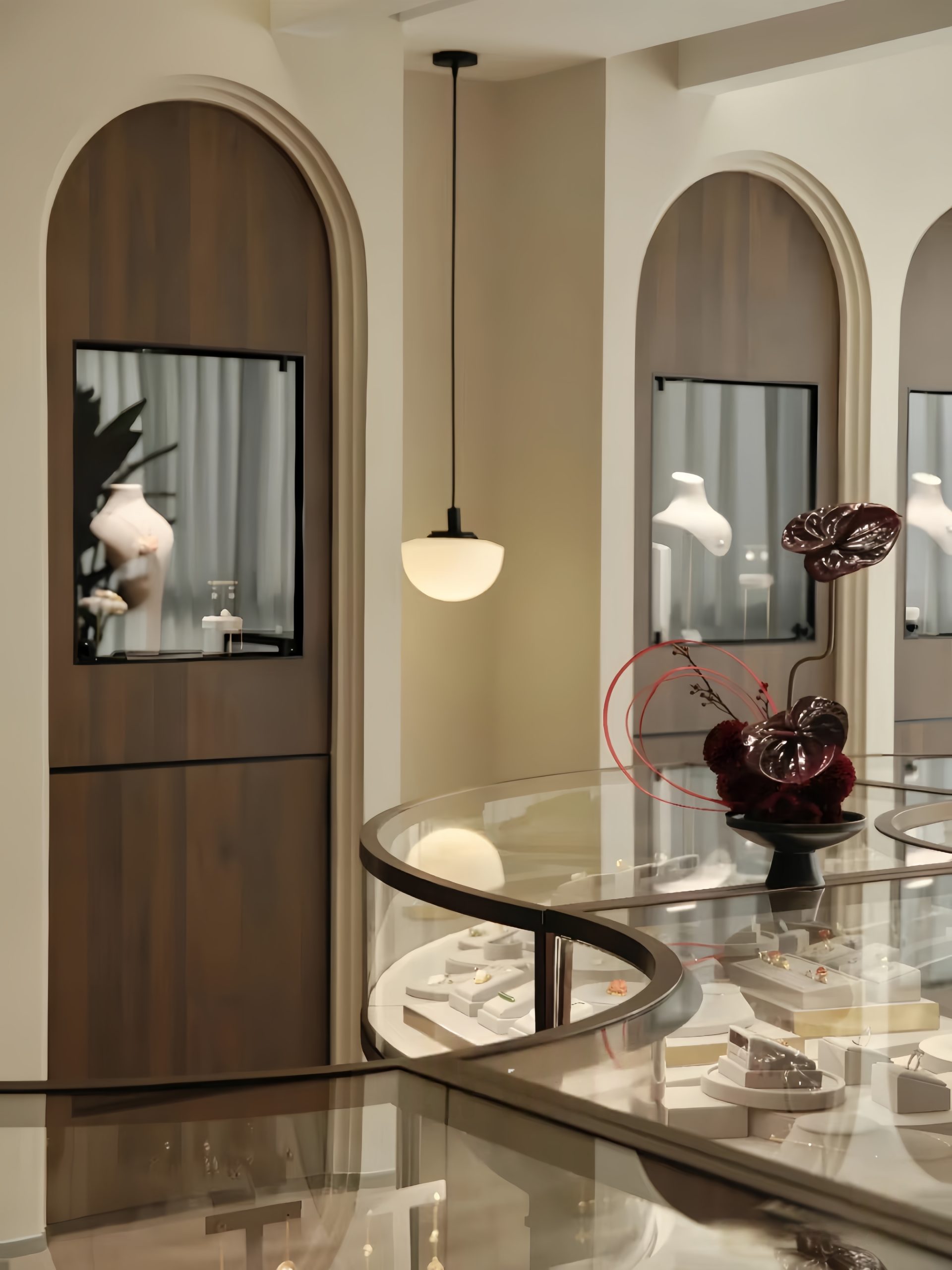 Elegant luxury jewelry boutique interior with arched wooden wall niches and curved glass jewelry display counters