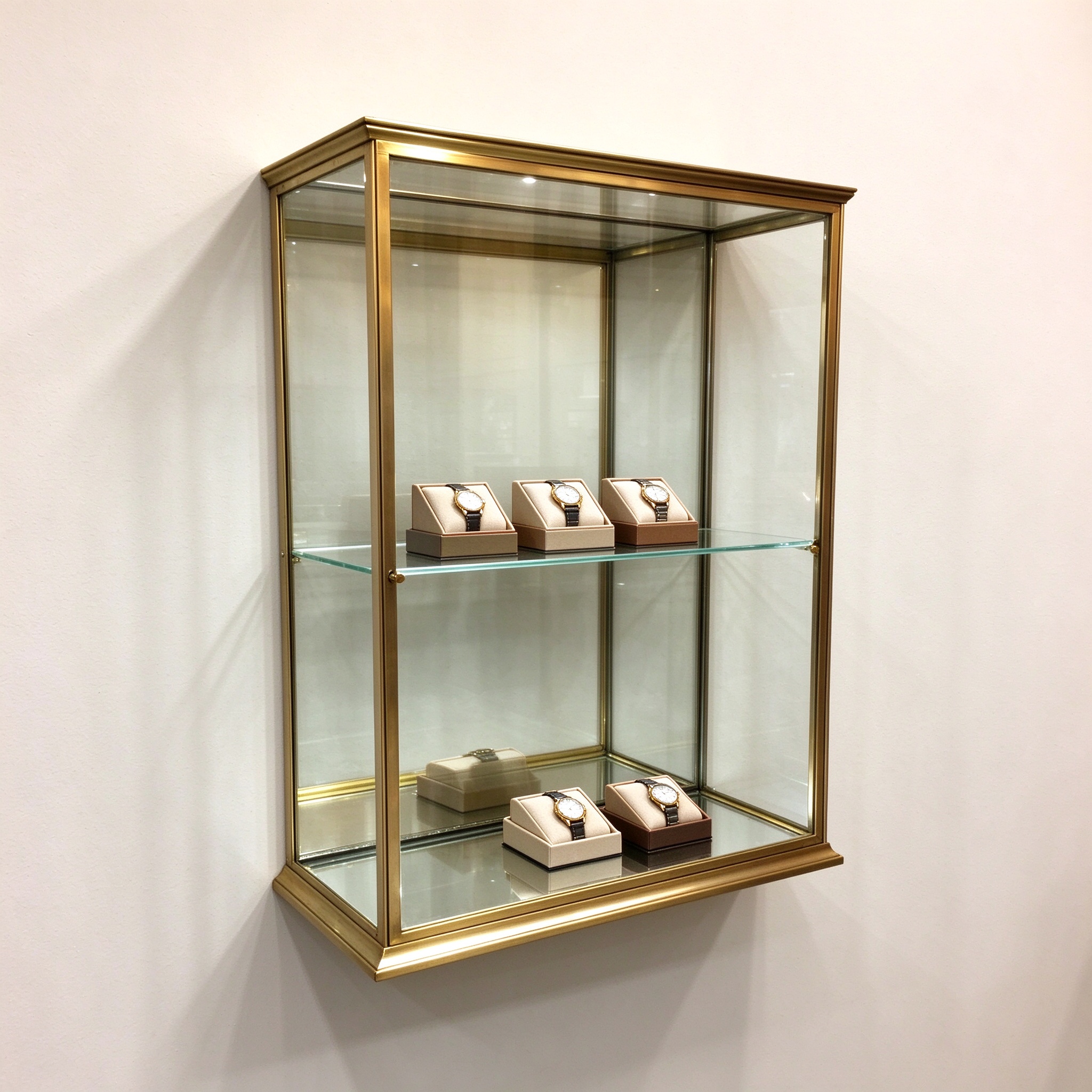 Brushed brass wall mounted glass vitrine left 45 degree view with watches